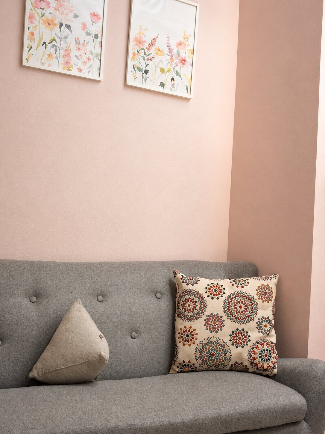 Rincón con sofá gris y una lámina floral en la pared