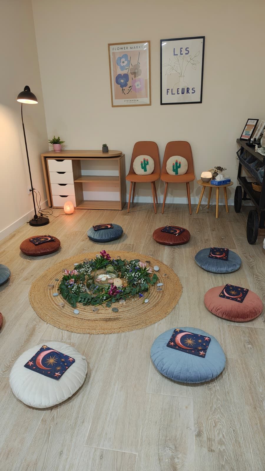 Sala del círculo de mujeres, con cojines de suelo alrededor de un centro de flores sobre una alfombra de yute